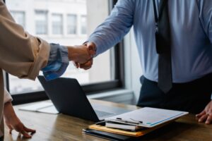 Resume objective examples - job seeker shaking hands with a hiring manager over a resume